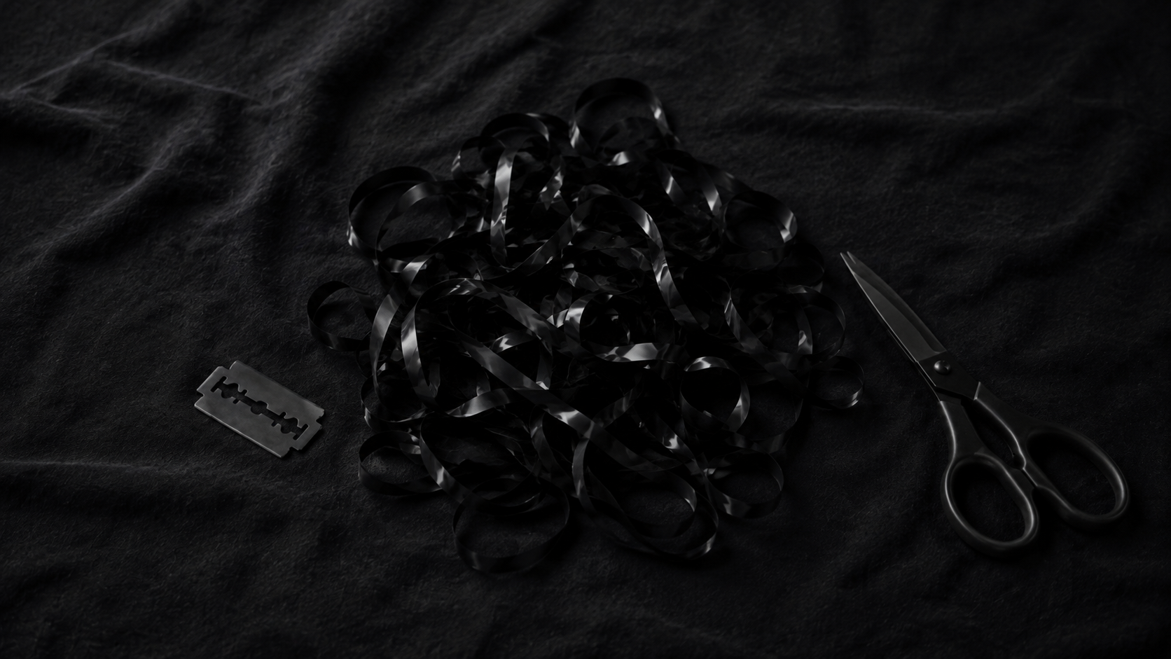 Black audio tape, scissors and a razor blade